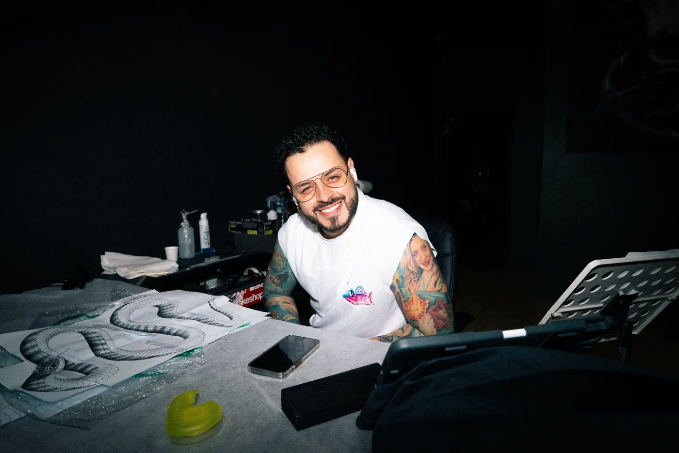 A Full Moon artist at the drawing desk with a snake sleeve design