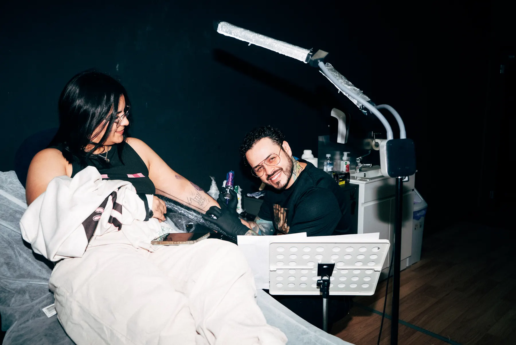 A Full Moon artist working on a forearm tattoo