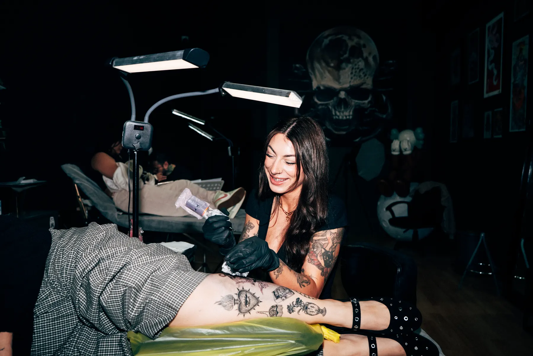 A Full Moon artist laughing with a client on the table