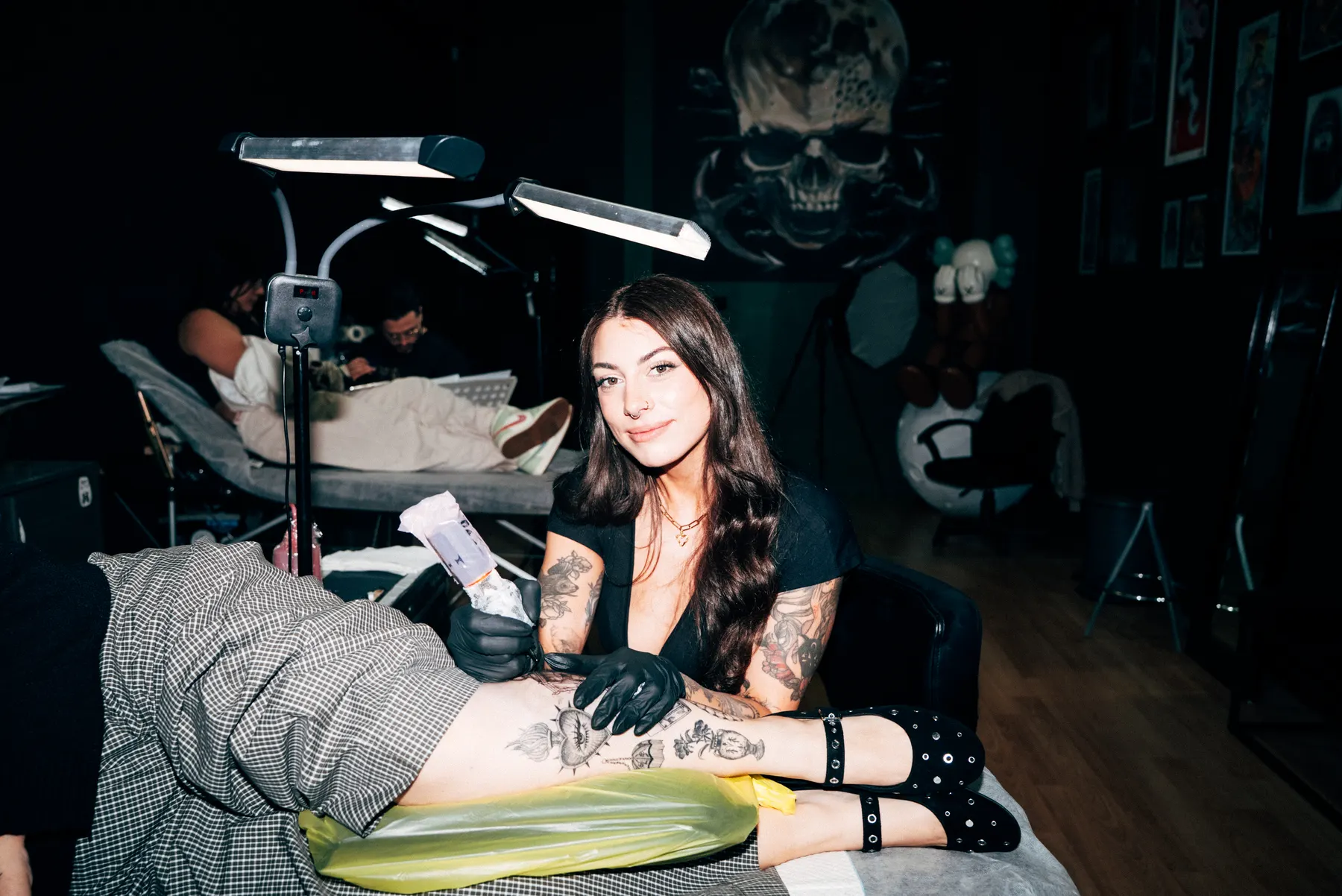 A Full Moon artist at her station with a fine line leg piece